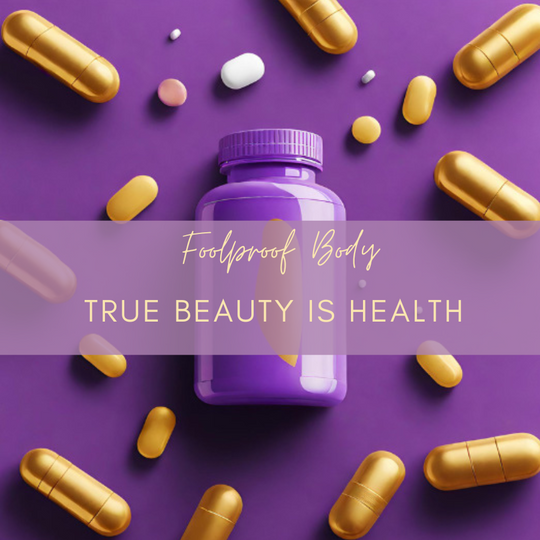 A photo of a purple and gold vitamin supplement bottle surrounded by yellow and gold capsules that match the color scheme. Text across the center reads Foolproof Body with the words true beauty is health written underneath. 