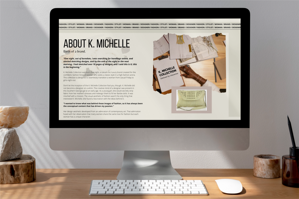 Website mockup showing a desktop monitor with About K. Michelle website page on screen. A black woman's hands designing clothes. A beige studded handbag. 